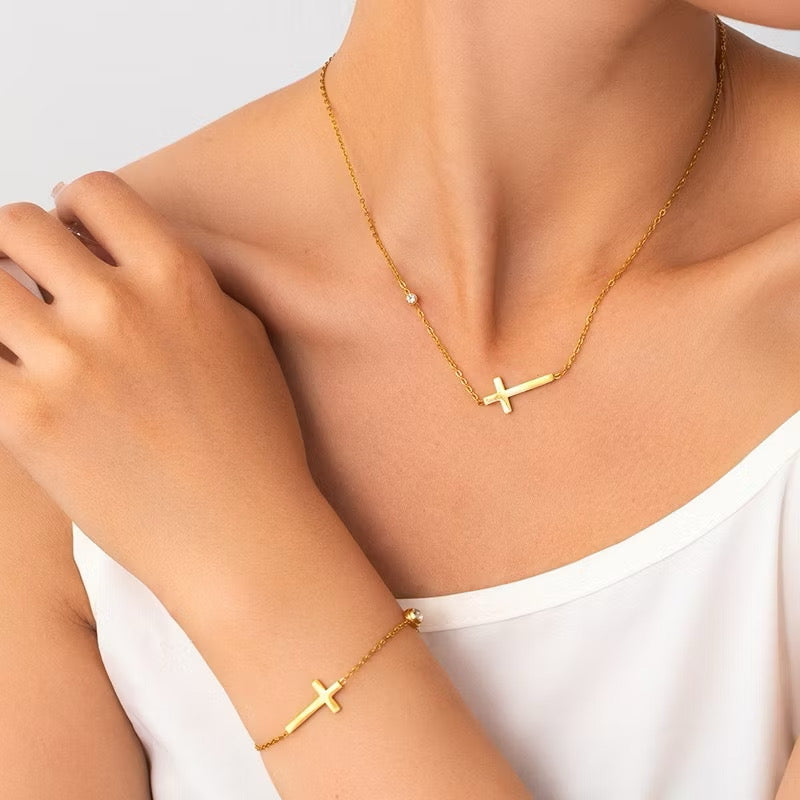 Conjunto de collar y pulsera con cruz de circonitas chapadas en oro.