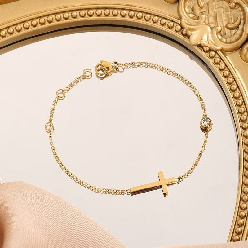 Conjunto de collar y pulsera con cruz de circonitas chapadas en oro.